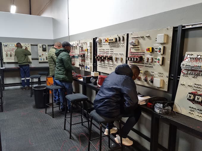 Learners working at wall-mounted electrical training boards